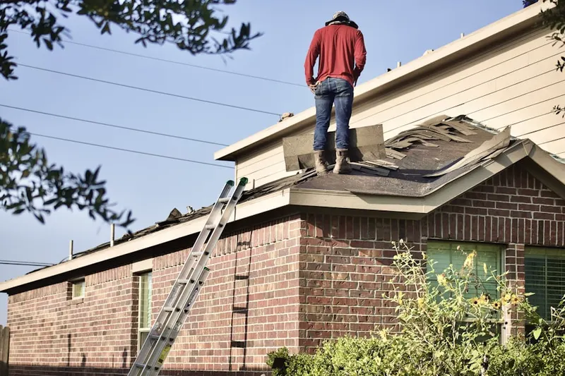 Professional roofer working on a residential roof in China Spring